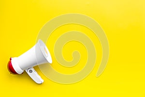 Announcement concept. Megaphone on yellow background top view copy space