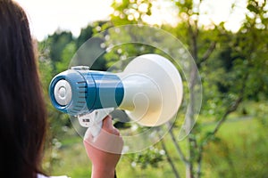 A woman holds a megaphone in her hand