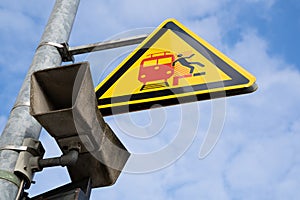 Announcement speaker and triangular warning sign for passengers on a german platform meaning beware of incoming and passing trains