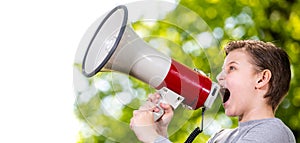 Announcing concept, boy shouting or screaming through the megaphone over forest background with copyspace