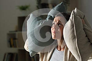 Annoyed adult woman suffering neighbour noise at night at home