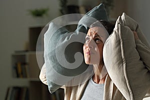 Annoyed adult woman suffering neighbour noise at night at home photo