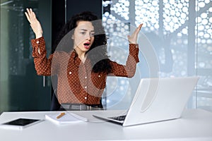 Annoyed and angry businesswoman inside office at workplace, hispanic woman disappointed received online notification of