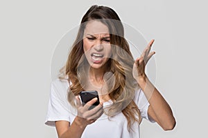 Annoyed angry woman mad about stuck phone isolated on background