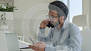 Annoyed Arabian businessman man arguing stressed dissatisfied boss quarrel call phone with laptop in office Indian guy