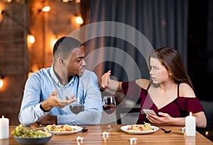 Annoyed Black Guy Blaming His Girlfriend For Using Smartphone During Romantic Dinner