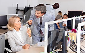 Annoyed boss scolding mature female subordinate pointing out shortcomings and misses in work