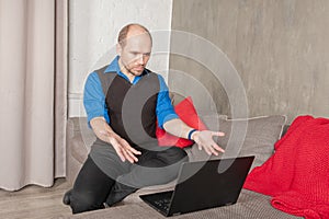 Annoyed business man with laptop working at home