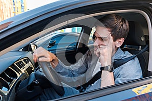 Annoyed businessman in car stuck in traffic jam photo