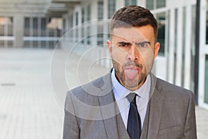 Annoyed businessman sticking his tongue out