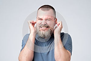 Annoyed caucasian man avoid hear bothering loud noise