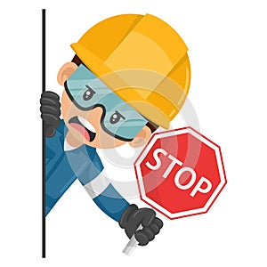 Annoyed industrial mechanical worker peeking out from behind a wall holding stop sign. Construction worker with his personal