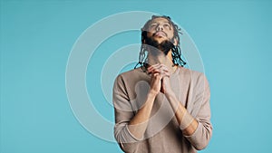 Annoyed man doing shushing hand gesturing, irritated by noise, studio background