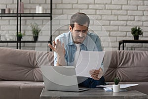 Annoyed man read letter with bad news at home office