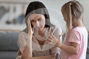 Annoyed mom and restless little daughter at home