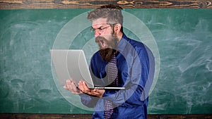 Annoyed by slow internet. Slowly internet annoying him. Teacher bearded man modern laptop chalkboard background. Hipster