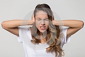 Annoyed stressed woman covering ears with hands feeling ear pain photo