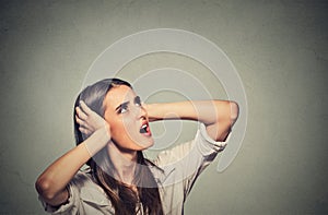 Annoyed stressed woman covering her ears, looking up loud noise upstairs