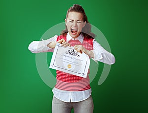 Annoyed student woman tearing Certificate of Graduation