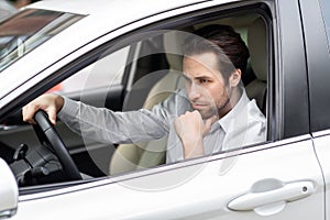 Annoyed tired young man riding driving car. Businessman late for meeting