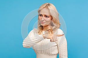 Annoyed upset woman with blond hair pointing finger to right, asking go away and leave her alone, conflict, crisis in