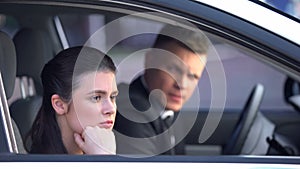 Annoyed woman looking out of car window, upset after quarrel with man, divorce