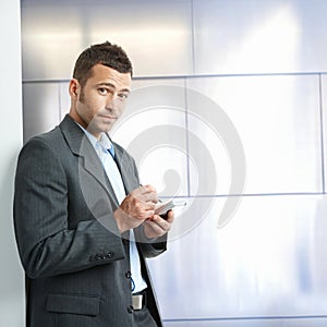 Annoyed young businessman in suit with tablet