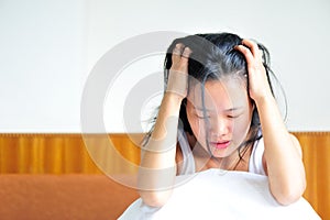 Annoyed young woman sitting on her bed