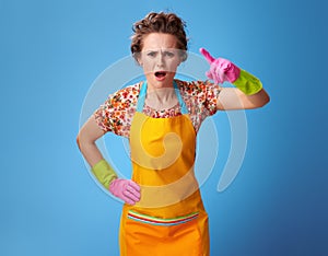 Annoyed young woman threatening with finger on blue