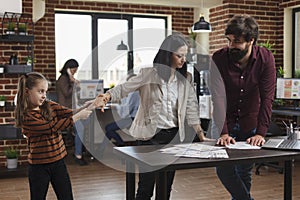 Annoying little girl disturbing busy working young mother while she trying to solve financial issues.