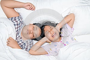 Sister closing ears with hands suffering from loud snore from her brother