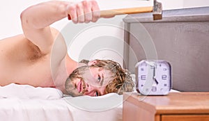 Annoying sound. Annoying ringing alarm clock. Man bearded annoyed sleepy face lay pillow near alarm clock. Guy knocking