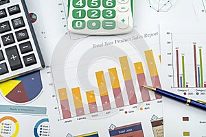 Annual financial document data charts with calculator pen on desk