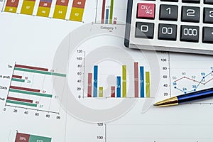 Annual financial document data charts with calculator pen on desk