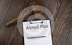 ANNUAL PLAN text on the paper with gavel on wooden background