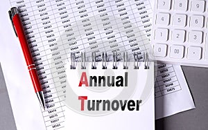 ANNUAL TURNOVER text on notebook with chart , pen and calculator