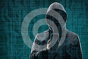 Anonymous computer hacker with a smartphone over abstract digital background. Obscured dark face in mask and hood. Data