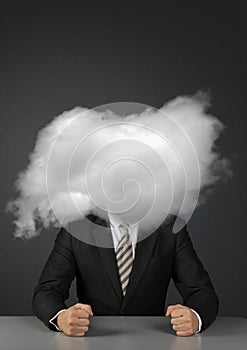 Anonymous concept, angry faceless businessman with head in clouds