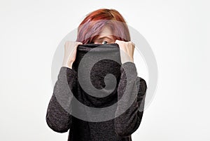 Anonymous concept. Young woman with interesting colorful hairstyle hiding her face with colar. photo
