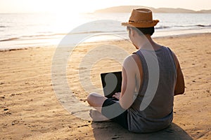 Anonymous freelancer using laptop near sea