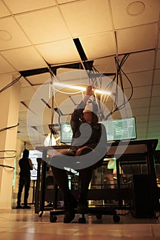 Anonymous hacker coding malware in ar, making hand gesture