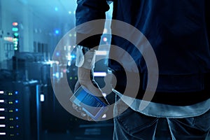 Anonymous hacker holding mobile phone