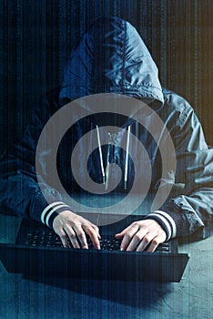 Anonymous hacker programmer uses a laptop to hack the system. Creation and infection of malicious virus.