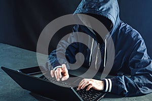 Anonymous hacker programmer uses a laptop to hack the system. Stealing personal data. Infection of malicious virus