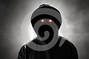 Anonymous hacker standing on smoke background