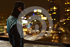 Anonymous hacker using mobile phone