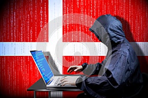 Anonymous hooded hacker, flag of Denmark, binary code - cyber attack concept