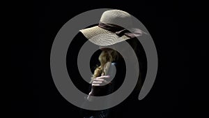 Anonymous lady in hat seductively stroking her body against dark background