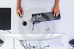 Anonymous male working on computer at table with graphic tablet