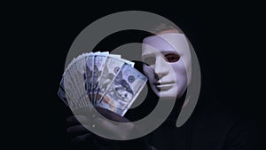 Anonymous man in mask enjoying big sum of money, receiving ransom for kidnapping